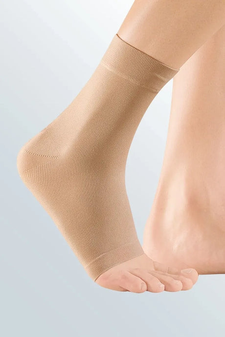 Beigefarbene Zweizug Knöchelbandage von medi am rechten Fuß getragen – elastisches Gestrick zur stabilisierenden Kompression des Sprunggelenks